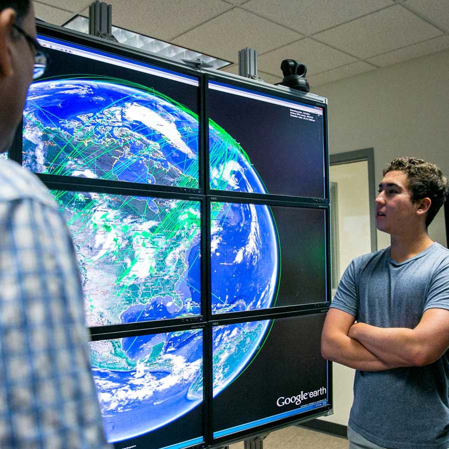 grad student looking at globe on screen