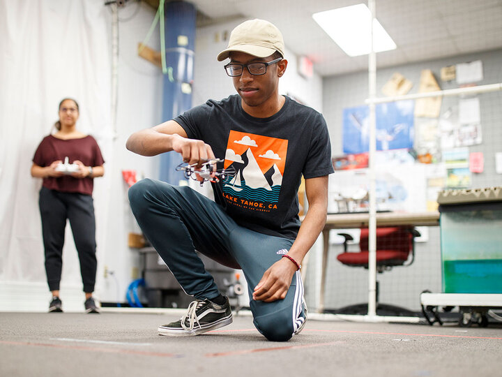 student flying drone