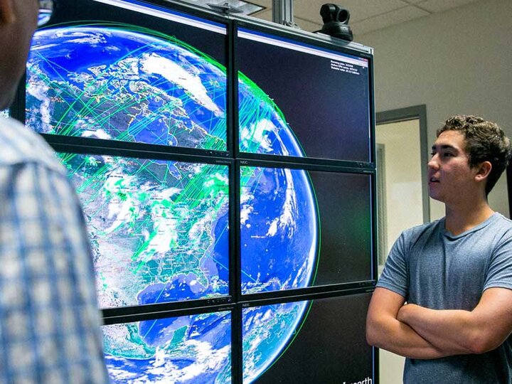 grad student looking at globe on screen