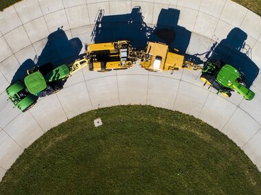 Green and yellow tractors from the Tractor Test Lab take an arching pathway.